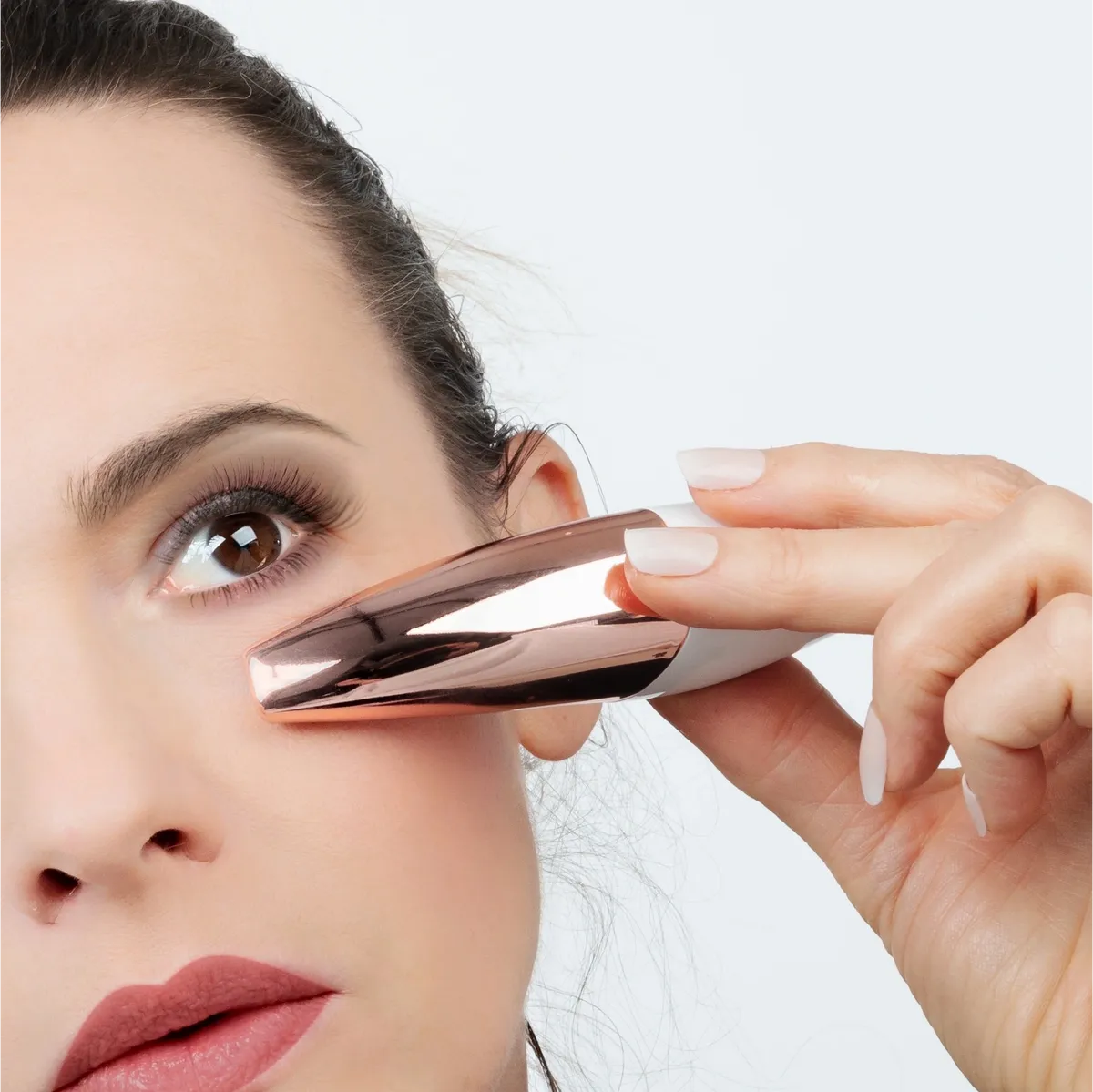 Person using i-BRATE facial wand under the eye to reduce puffiness